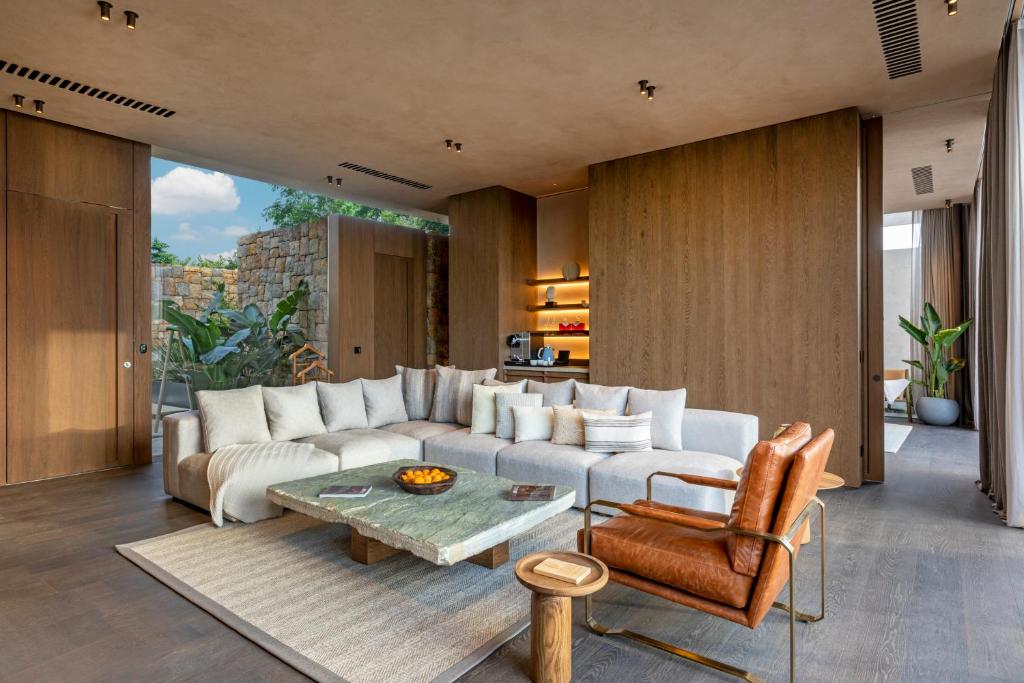 Mūsdienīgs viesnīcas Lujo Hotel Bodrum numurs ar greznu viesistabu un dabas elementiem.