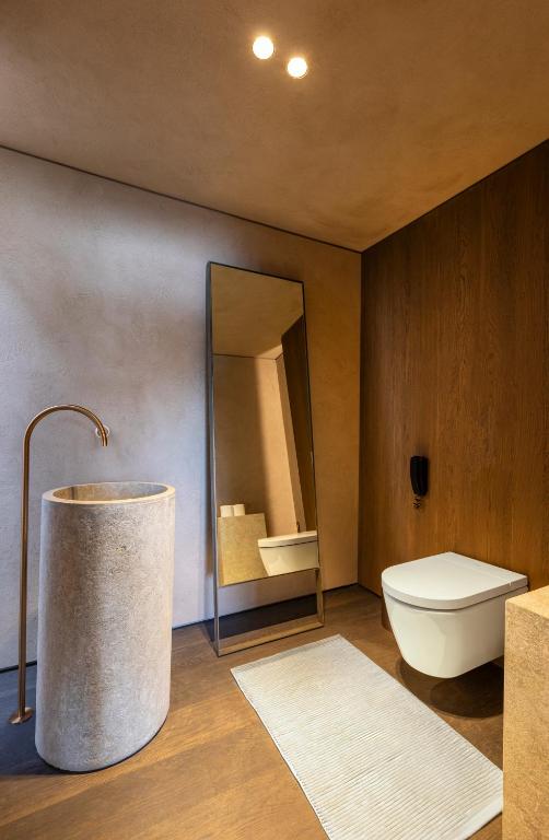 Mūsdienīga vannas istaba Lujo Hotel Bodrum ar akmens izlietni un spoguli.