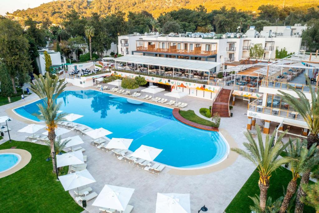 DoubleTree by Hilton Bodrum Isil Club Resort baseins ar sauļošanās krēsliem un viesnīcu