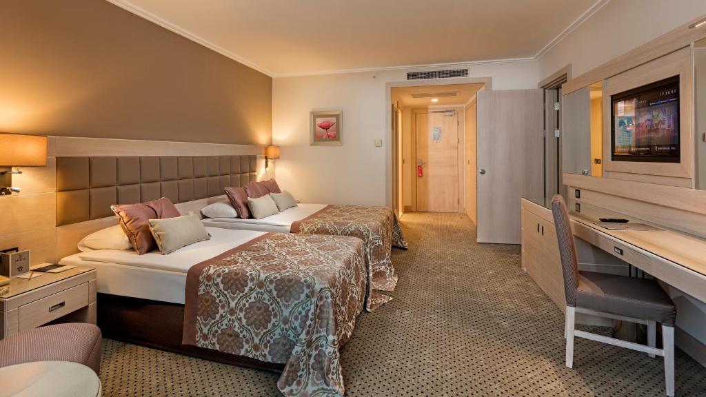 Moderns numurs Miracle Resort Hotel ar divām gultām un darba galdu.