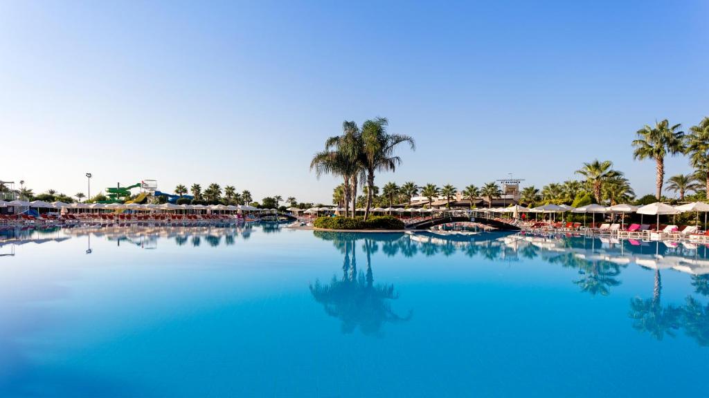 Miracle Resort Hotel baseins ar palmām un saules gultām