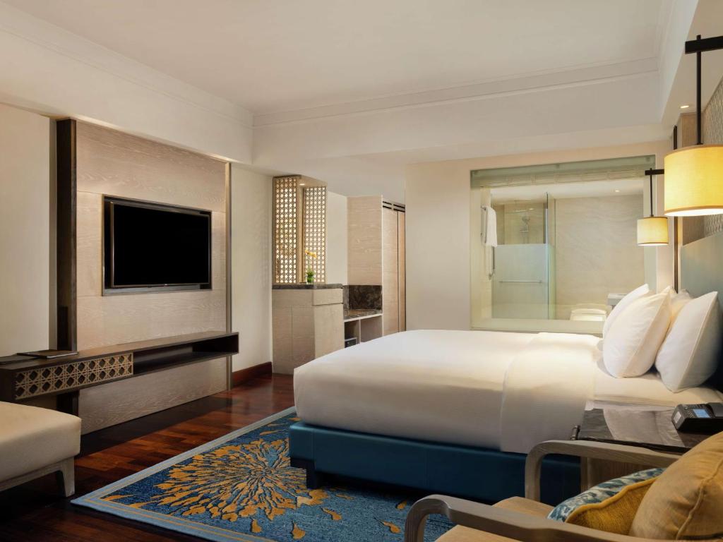 Mūsdienīgs viesnīcas numurs ar ērtu gultu, televizoru un stikla dušas kabīni. Interjers ir gaišs un elegantas krāsas, radot relaksējošu atmosfēru.