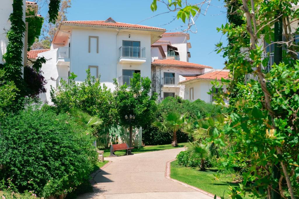 Zaļš dārzs un baltas ēkas pie Belconti Resort Hotel