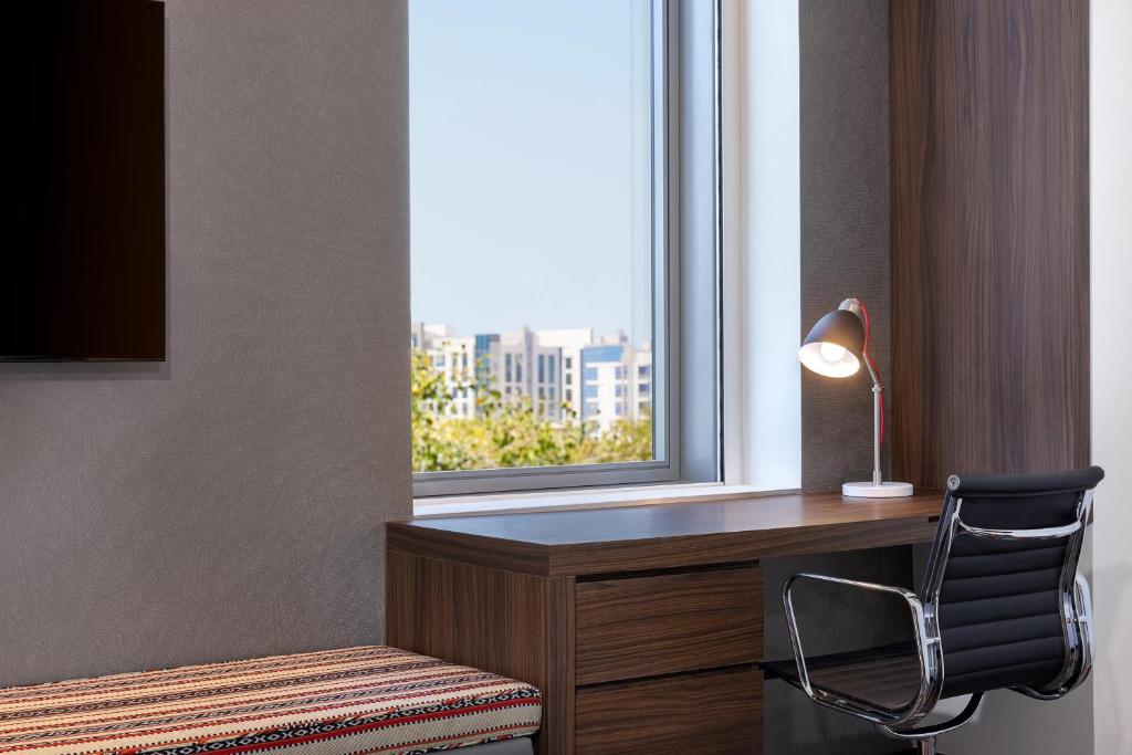 Aloft Al Mina numurs ar rakstāmgaldu un skatu pa logu