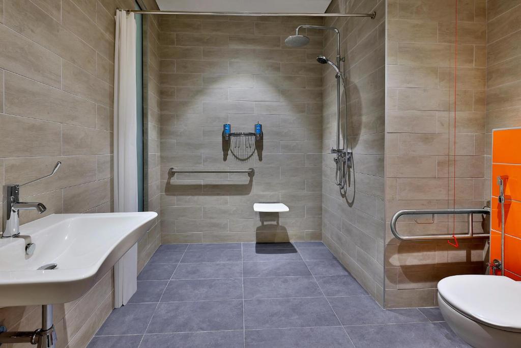 Aloft Al Mina bezbarjeru vannas istaba ar modernu dizainu