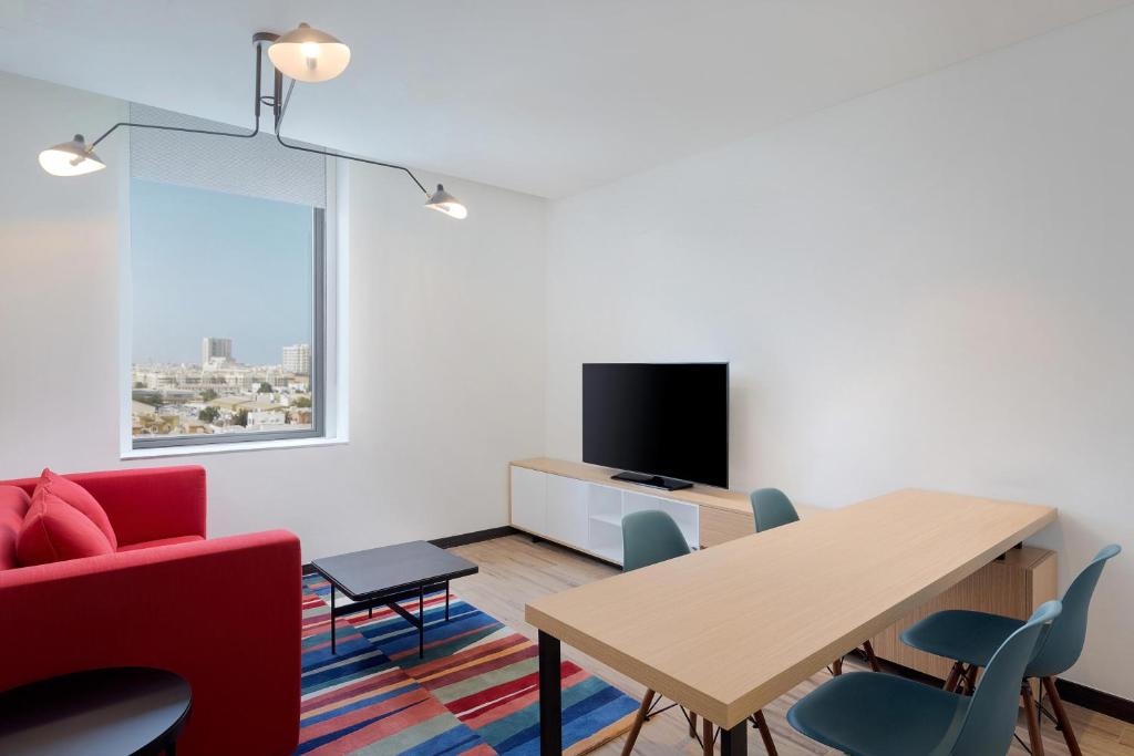 Mūsdienīgs Aloft Al Mina numurs ar skatu uz pilsētu.