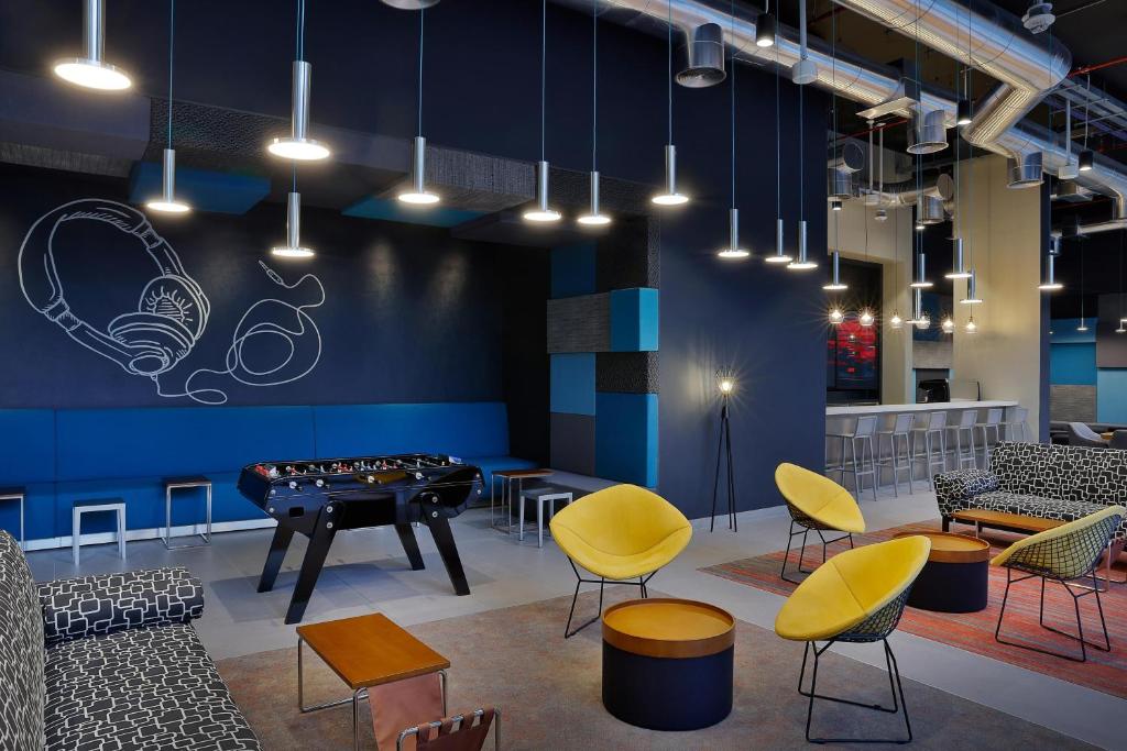 Aloft Al Mina modern lounge with foosball and seating area.