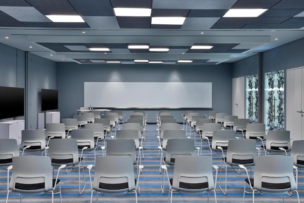 Konferenču telpa Aloft Al Mina viesnīcā ar modernu aprīkojumu.