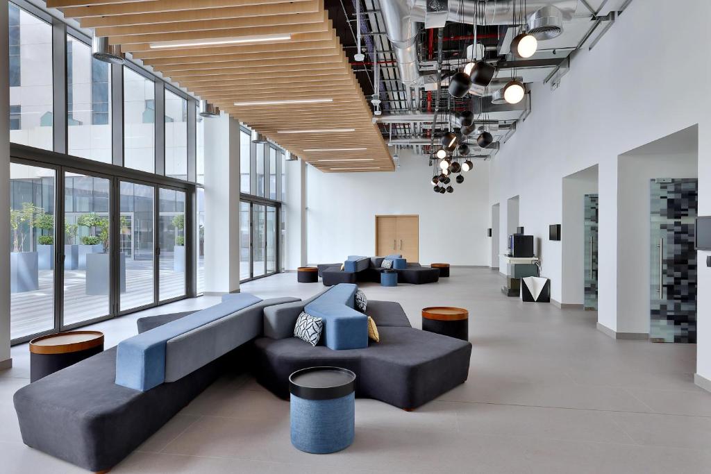 Mūsdienīgs vestibils Aloft Al Mina viesnīcā ar stilīgu mēbelējumu.