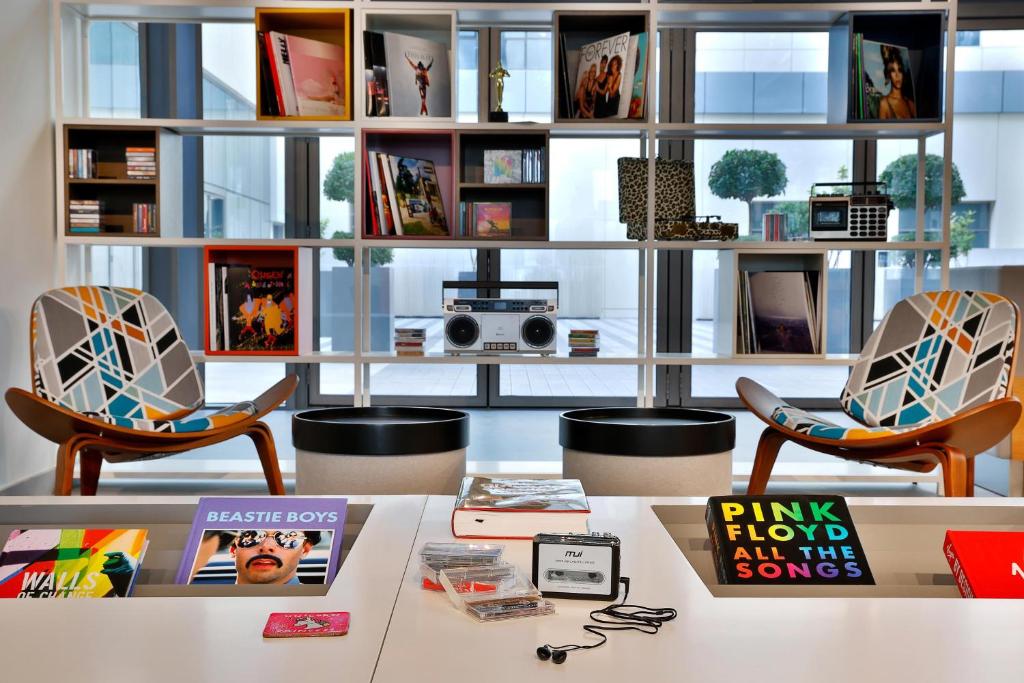 Aloft Al Mina mūsdienīga atpūtas zona ar plauktiem un krēsliem