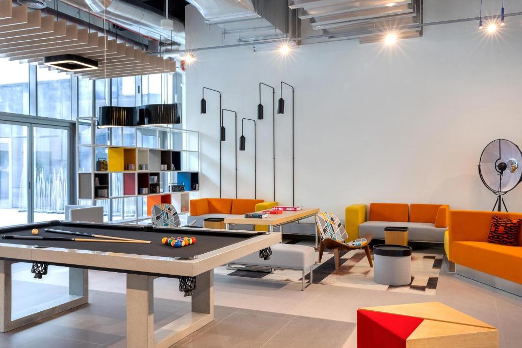 Aloft Al Mina atpūtas telpa ar biljarda galdu.