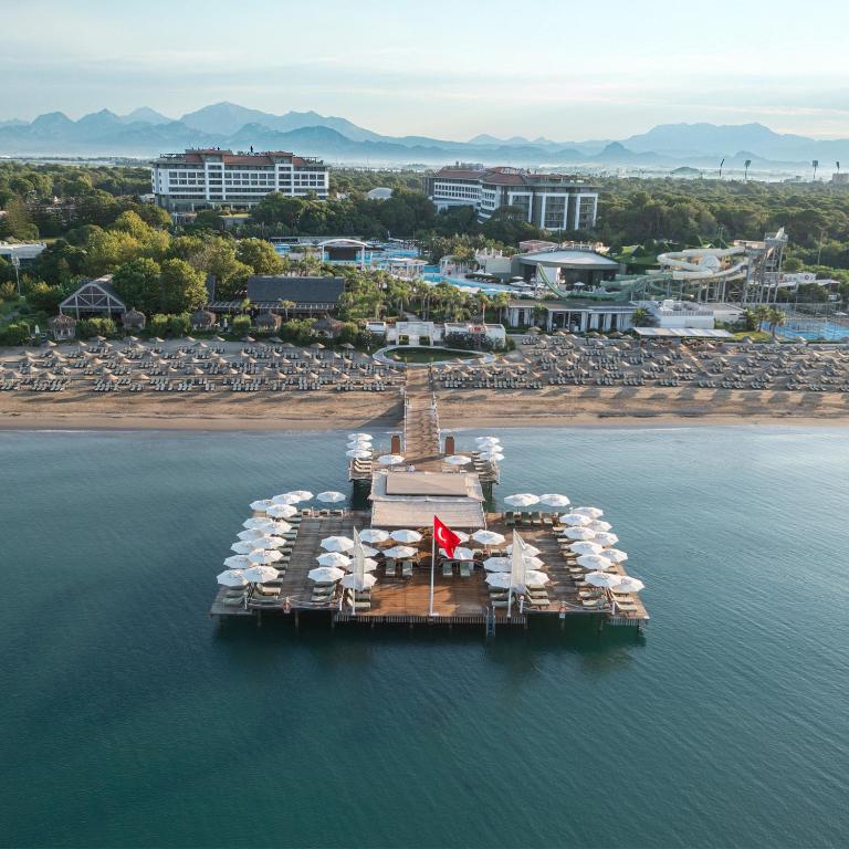 Skats uz Ela Excellence Resort Belek piekrastes molu un apkārtējo dabu. panoramic view with beach and pools