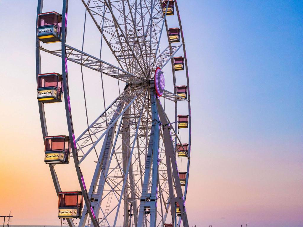 Lielais rats ar krāsainām kabīnēm pret saulrietu, radot pasakainu atmosfēru.