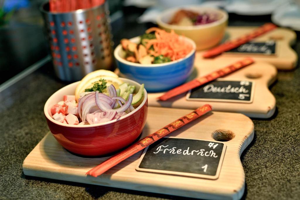 Svaigas sastāvdaļas dažādās bļodās, pie galda ar nūjiņām un nosaukumu kartītēm. Izsmalcināta ēdiena prezentācija, kas iedvesmo kulinārijas mīļotājus.