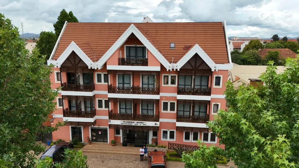 Hotel Plumeria fasāde ar zaļumiem priekšplānā.