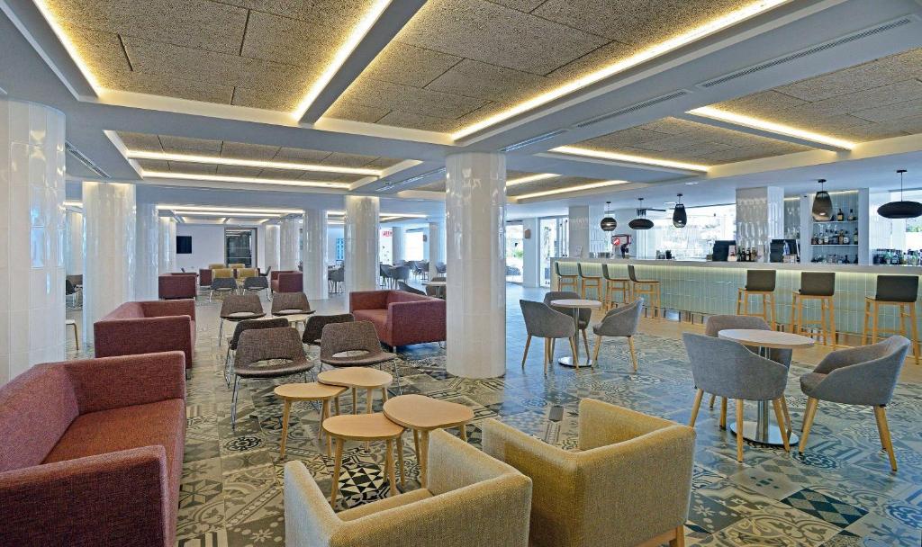 Mūsdienīga interjera dizaina kafejnīca ar elegantiem dīvāniem un galds, kas veidots relaksējošai atmosfērai. Interjers izceļas ar stilīgu apgaismojumu un dekoratīvu grīdu.