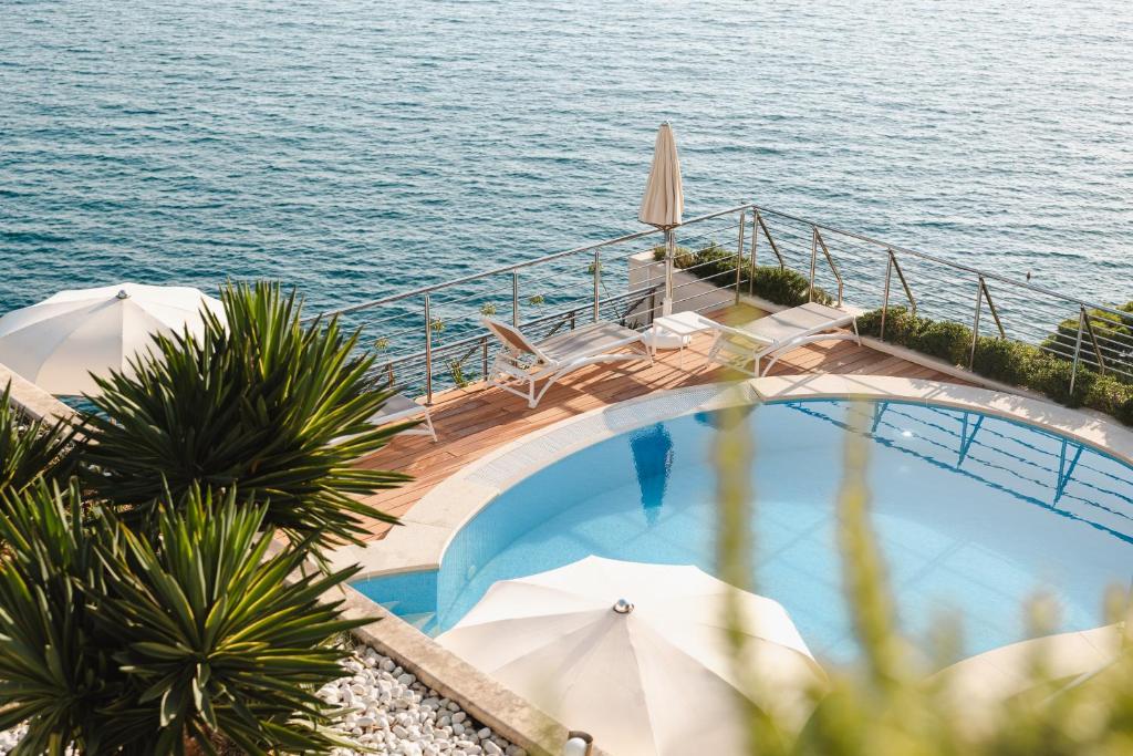 Peldbaseins ar skatu uz jūru, apkārt augi un sauļošanās krēsli. Ideāls atpūtas un relaksācijas vieta.