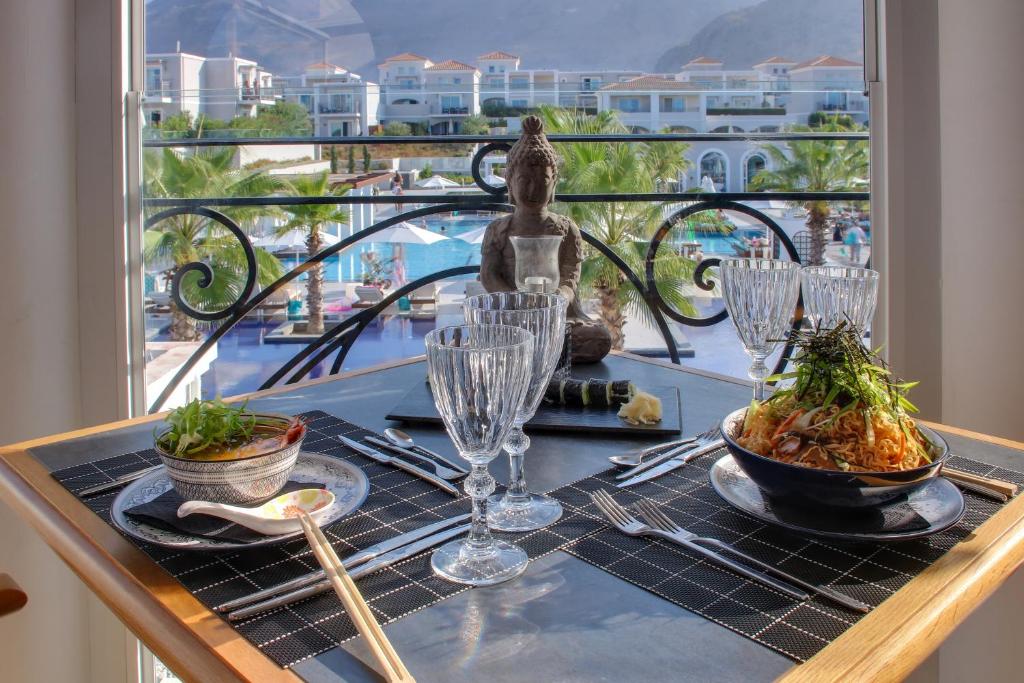 Elegantā galda klāšana ar japāņu ēdieniem un skatu uz baseinu un palmu dārzu. Svaigi sastāvdaļas un dekors piešķir atmosfēru relaksācijai.