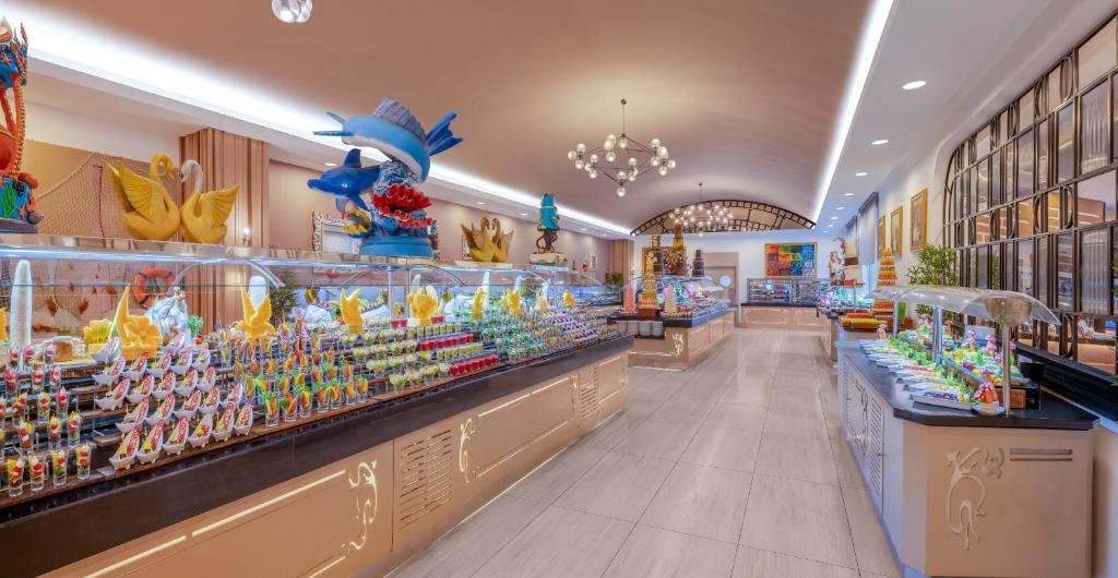 Delphin Diva bagātīgs deserts ar krāsainām konfektēm un rotājumiem