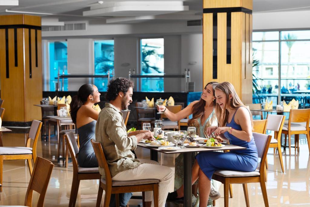 Viesi izbauda maltīti eleganta restorānā hotelī Pickalbatros Royal Albatros Moderna.