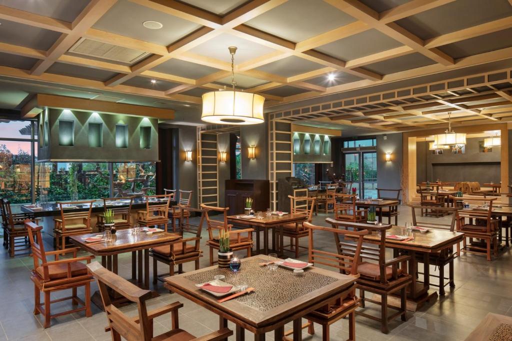 Moderns restorāns pie Ela Excellence Resort Belek ar elegantiem galdiem un krēsliem.