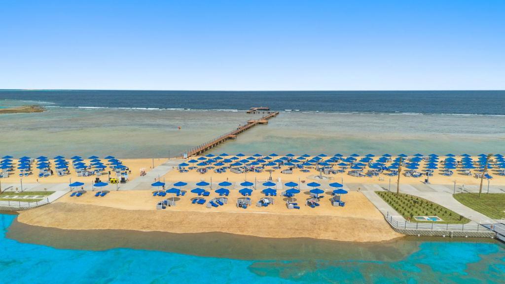 Pludmale ar zeltainu smilšu un ziliem saulessargiem, blakus ir koka piestātne un skaidrs ūdens. Ideāla vieta atpūtai un saulē.