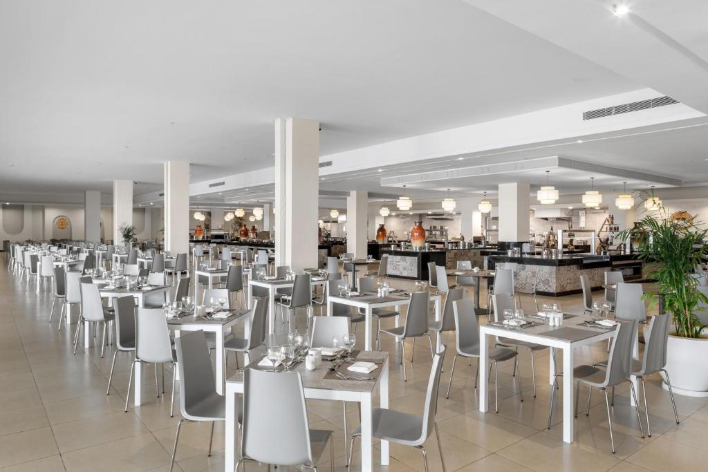 Mūsdienīgs restorāns ar plašu, gaišu interjeru, kurā ir eleganti galdi un krēsli. Ēdamzāle ir sakārtota ar vāzēm un traukiem, kas piešķir atmosfēru.