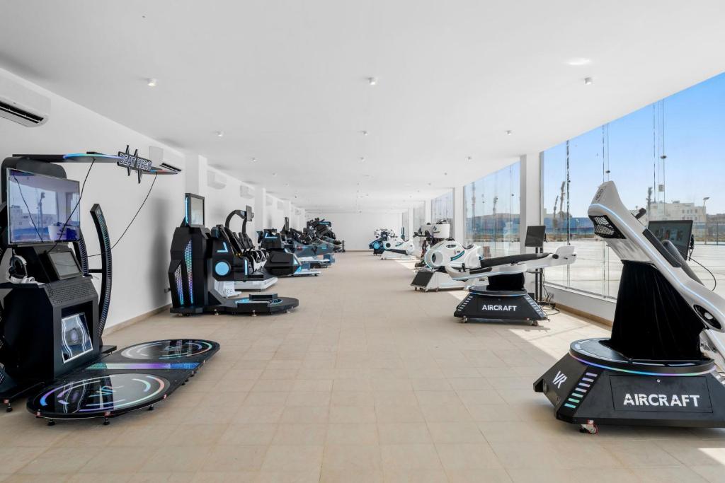 Modernu virtuālo realitātes simulāciju iekārtu telpa ar dažādām VR ierīcēm un plašiem logiem.