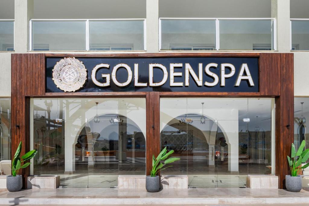 Zelta spa centra ieeja ar modernu dizainu un skaidru logotipu. Pievilcīgas augu kompozīcijas pie durvīm papildina mierīgu atmosfēru.