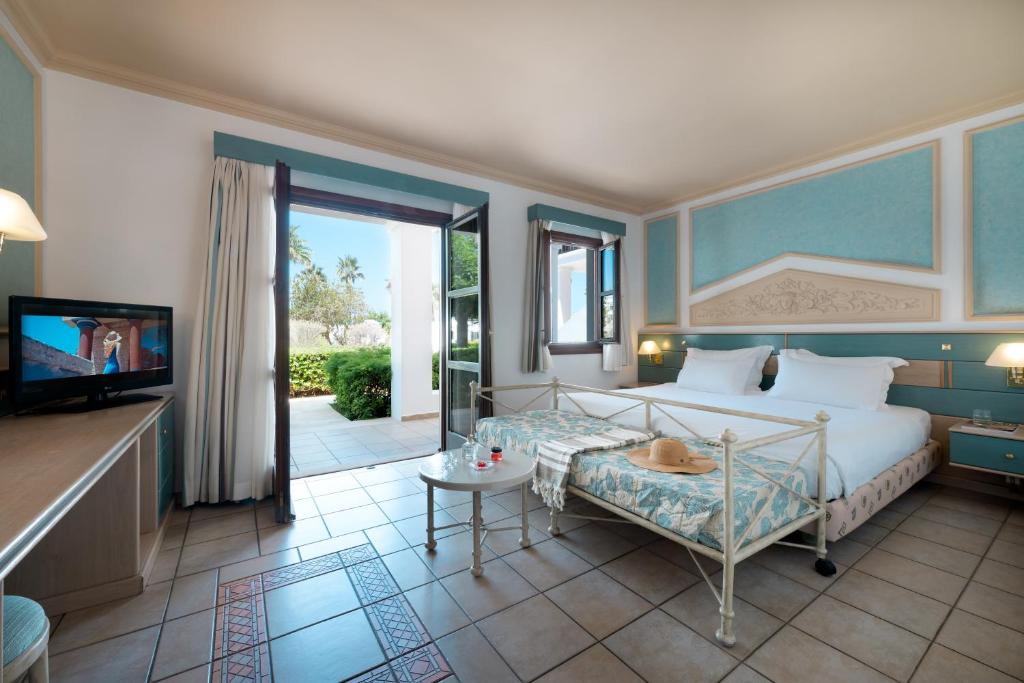 Mitsis Royal Mare numurs ar divām gultām un terasi, skats uz dārzu.