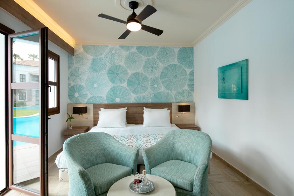 Mitsis Royal Mare numurs ar skatu uz baseinu un modernu interjeru.