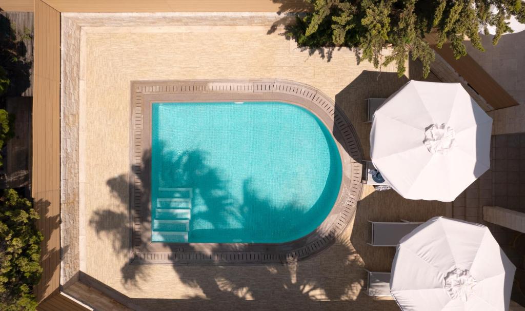 Mitsis Royal Mare viesnīcas peldbaseins ar saules sargiem piekrastē.