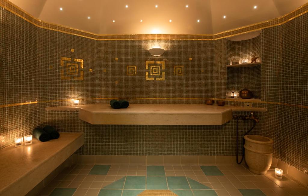 Mitsis Royal Mare spa telpa ar mozaīkas sienām un siltu apgaismojumu.