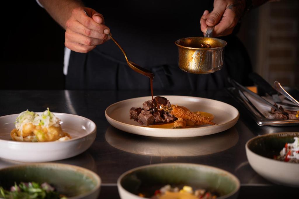 Šefpavārs piešķir mērci ēdienam viesnīcā Mitsis Royal Mare.