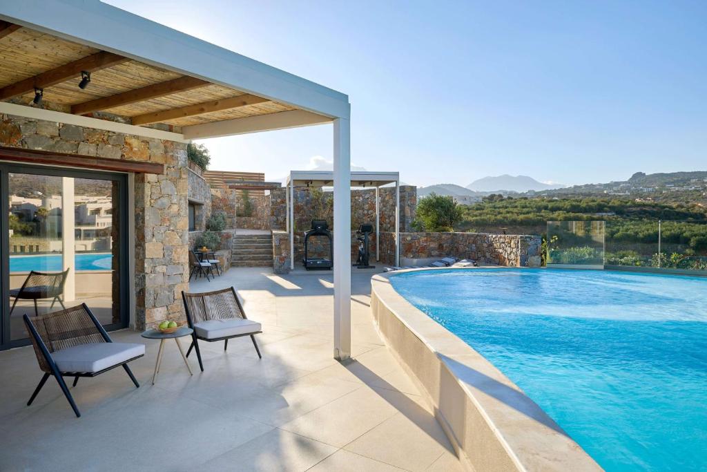 Mirabello Bay Luxury Resort terase ar privātu baseinu un skatu uz kalniem.