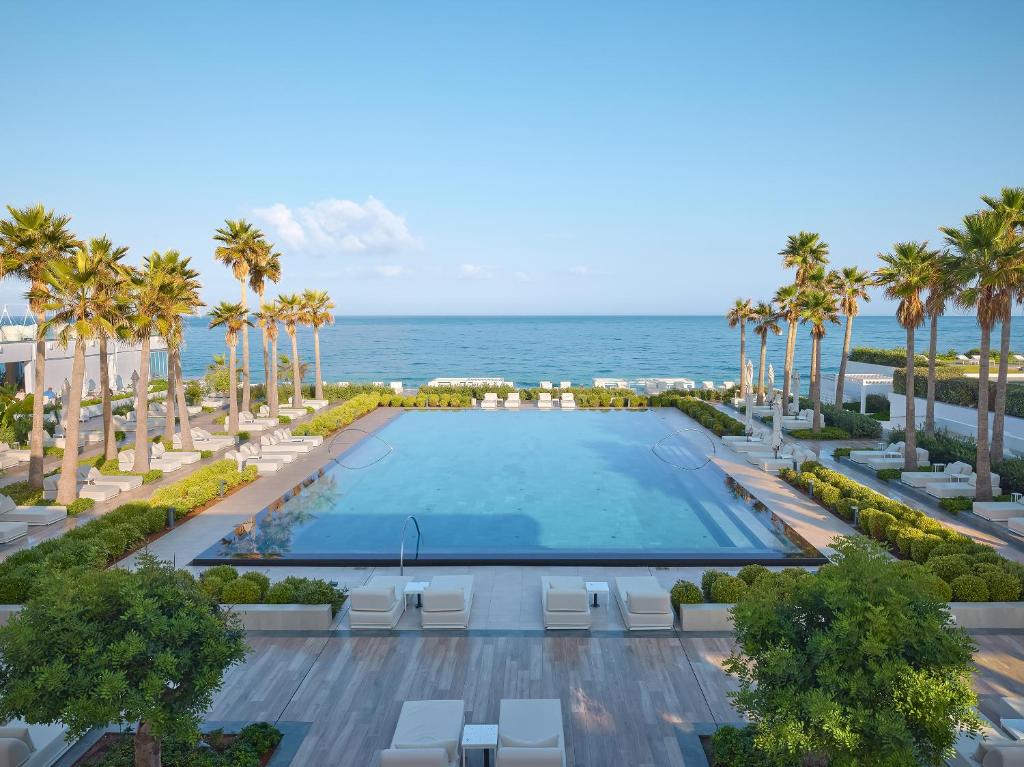 Grecotel Lux Me White Palace baseins ar palmām piekrastē