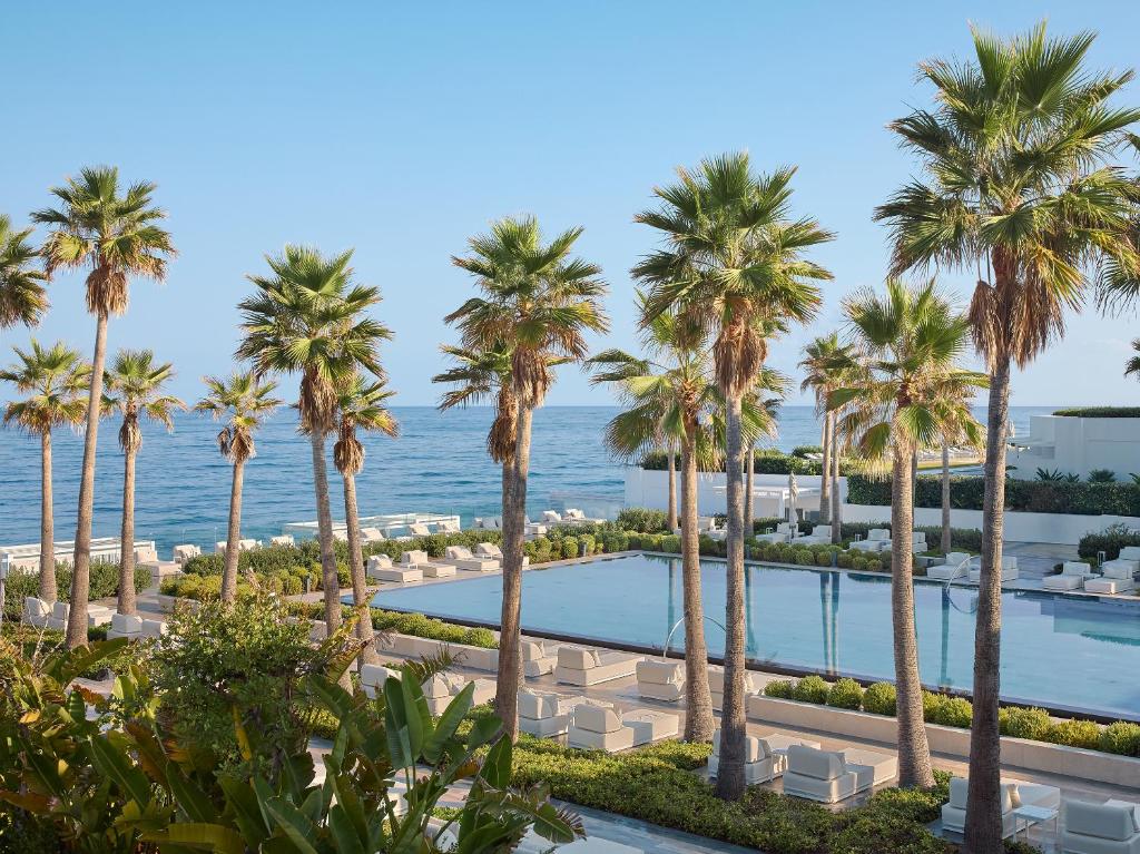 Grecotel Lux Me White Palace baseins piekrastē, starp palmām