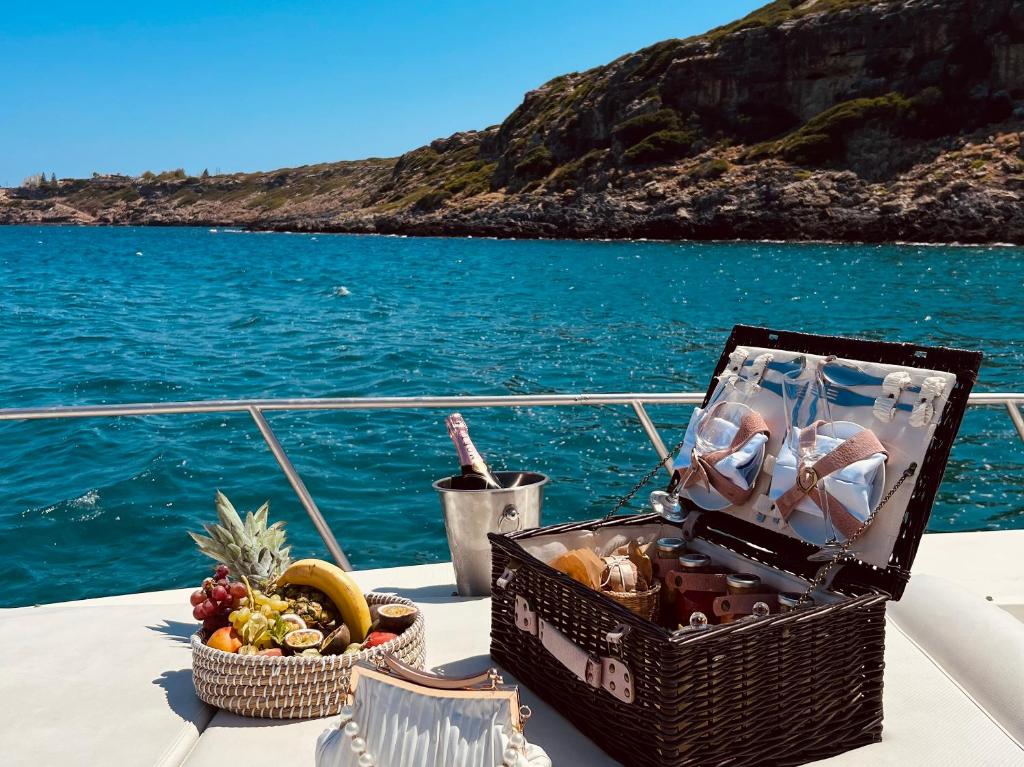 Grekotela Lux Me White Palace laivu pikniks ar augļiem un šampanieti piekrastē.