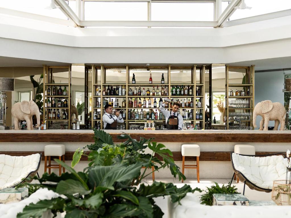 Grecotel Lux Me White Palace bārs ar dzērienu plauktiem un apkalpojošiem bārmaniem