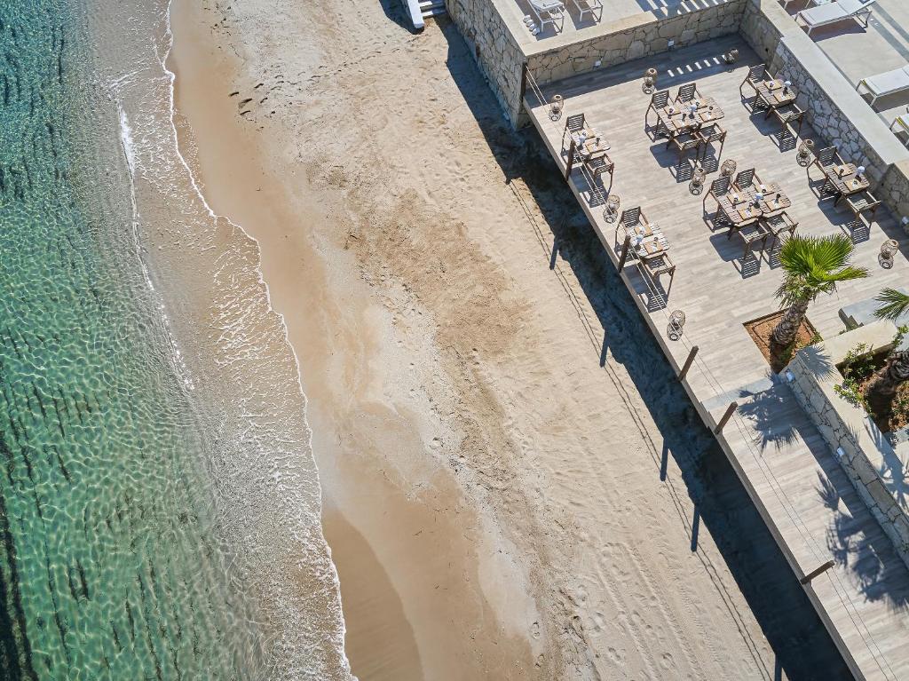 Grecotel Lux Me White Palace piekrastes skats ar terasi un pludmali.