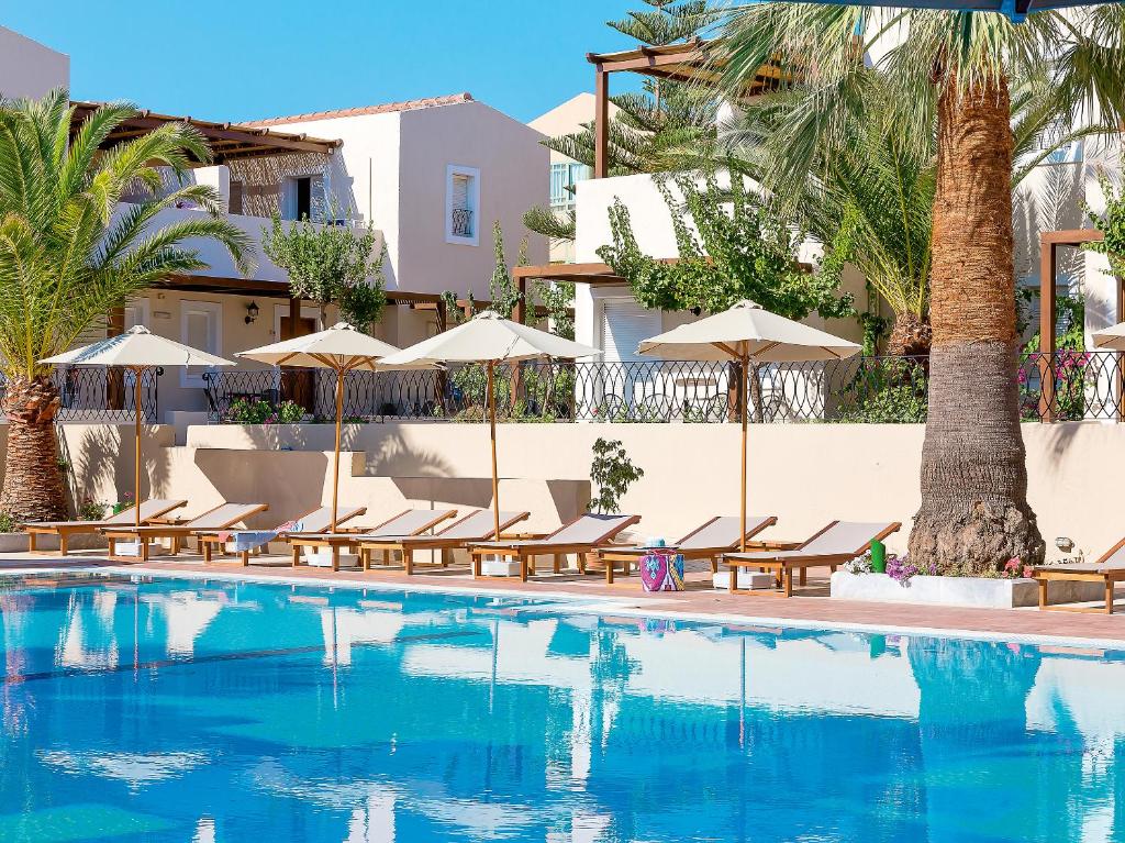 Grecotel Casa Adele baseins ar sauļošanās krēsliem un lietussargiem