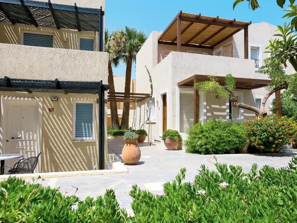 Grecotel Casa Adele numuru komplekss ar zaļumiem un palmām piekrastē