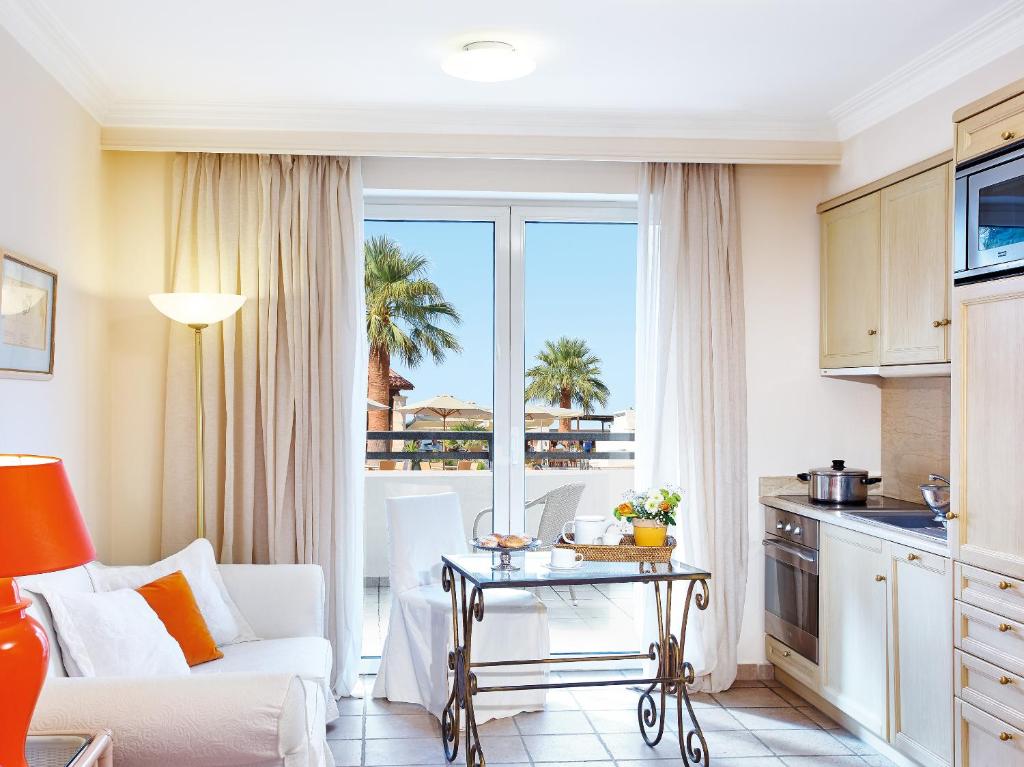 Grecotel Casa Adele numurs ar skatu uz palmu dārzu un balkonu.