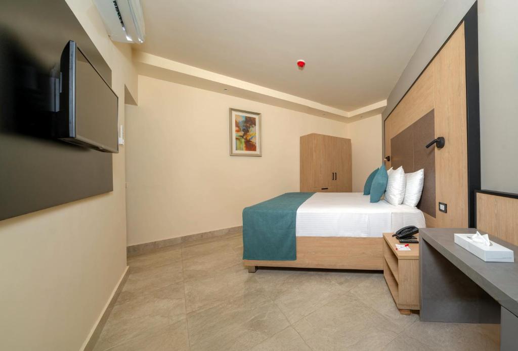 Mūsdienīgs numurs Xperience Kiroseiz Parkland ar televizoru un ērtu gultu.