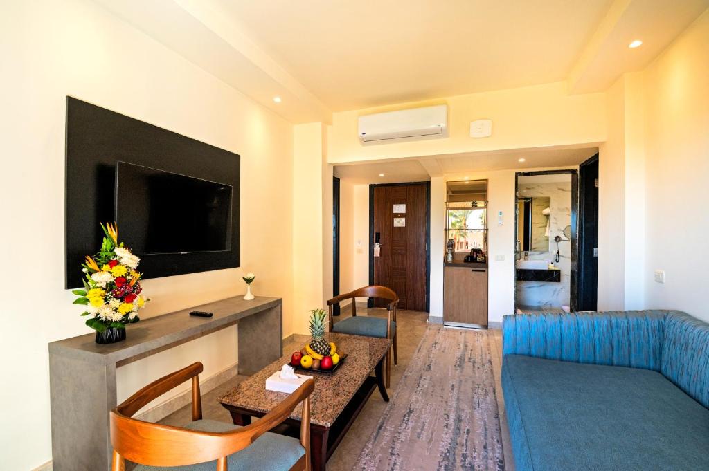 Mūsdienīgs viesnīcas numurs Xperience Kiroseiz Parkland ar televizoru un ērtu dīvānu.