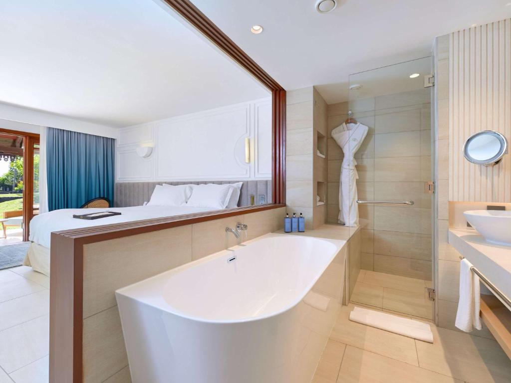 Mūsdienīgs viesnīcas numurs ar vannu un dušu, kas piedāvā komfortu un relaksāciju. Gaismas toņos iekārtots interjers ar piekļuvi dārzam.