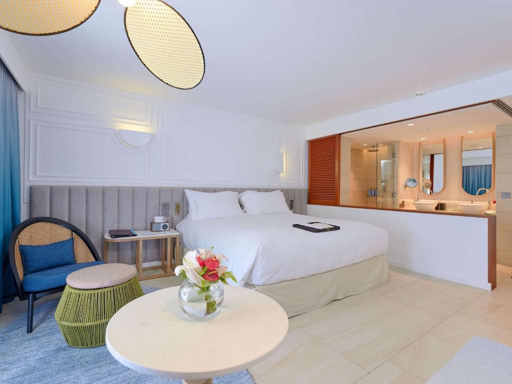 Mūsdienīgs viesnīcas numurs ar plašu gultu, ērtu sēžamo stūrīti un modernu vannas istabu. Interjers ir gaišs un elegants, radot relaksējošu atmosfēru.