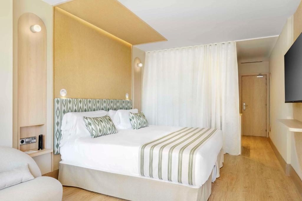 Mūsdienīgs viesnīcas numurs ar plašu gultu, kas rotāta ar stilīgām spilveniem un gaismas elementiem, radot ērtu un relaksējošu atmosfēru. Interjers ir gaišs un minimālistisks, ar dabīgu koka grīdu un mūsdienīgu televizoru.