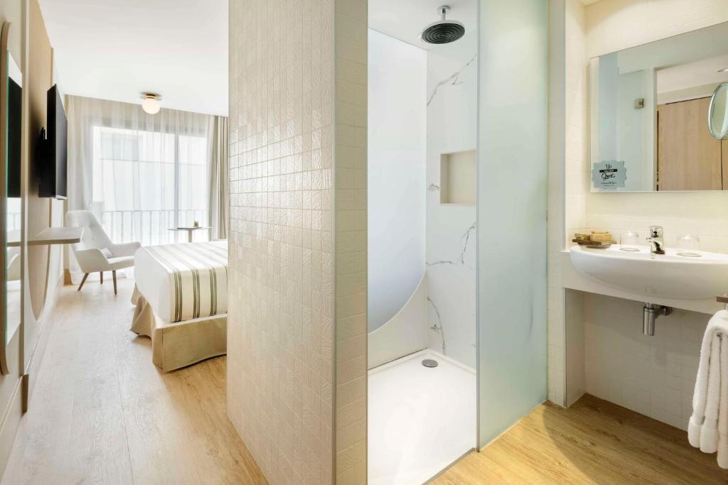 Mūsdienīgs viesnīcas numurs ar atvērtu dušu un elegantu iekārtojumu. Gaisīga telpa ar dabīgu apgaismojumu un mūsdienīgām mēbelēm.