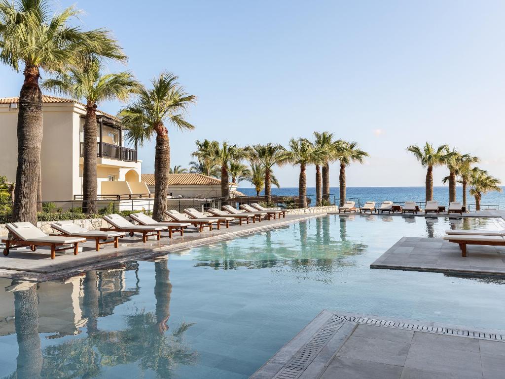 Grecotel Marine Palace & Aqua Park baseins ar palmām piekrastē